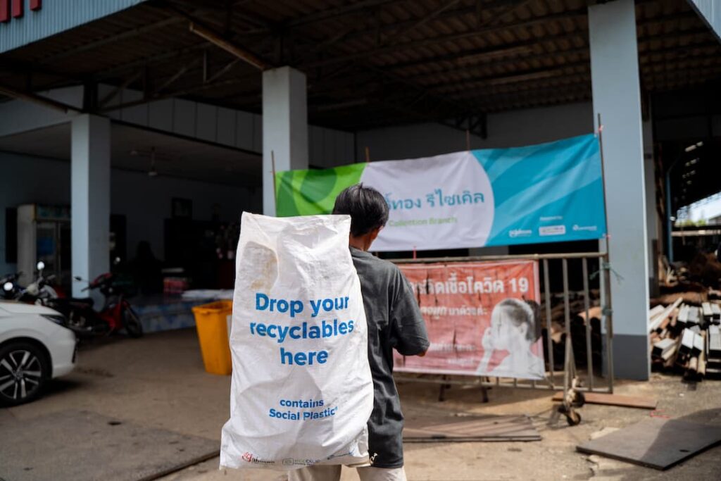 Collector from Thailand holding a bag full of plastic 