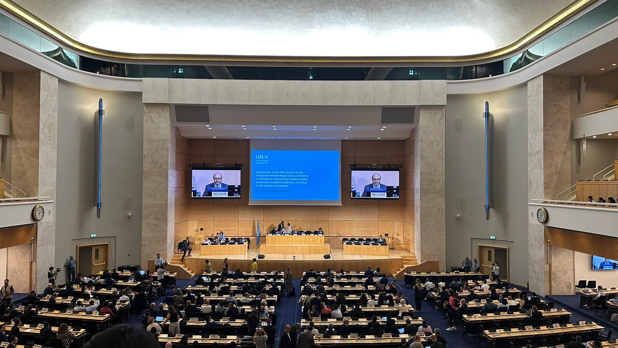 People in plastic treaty in Geneva in the hall discussing the global issue 