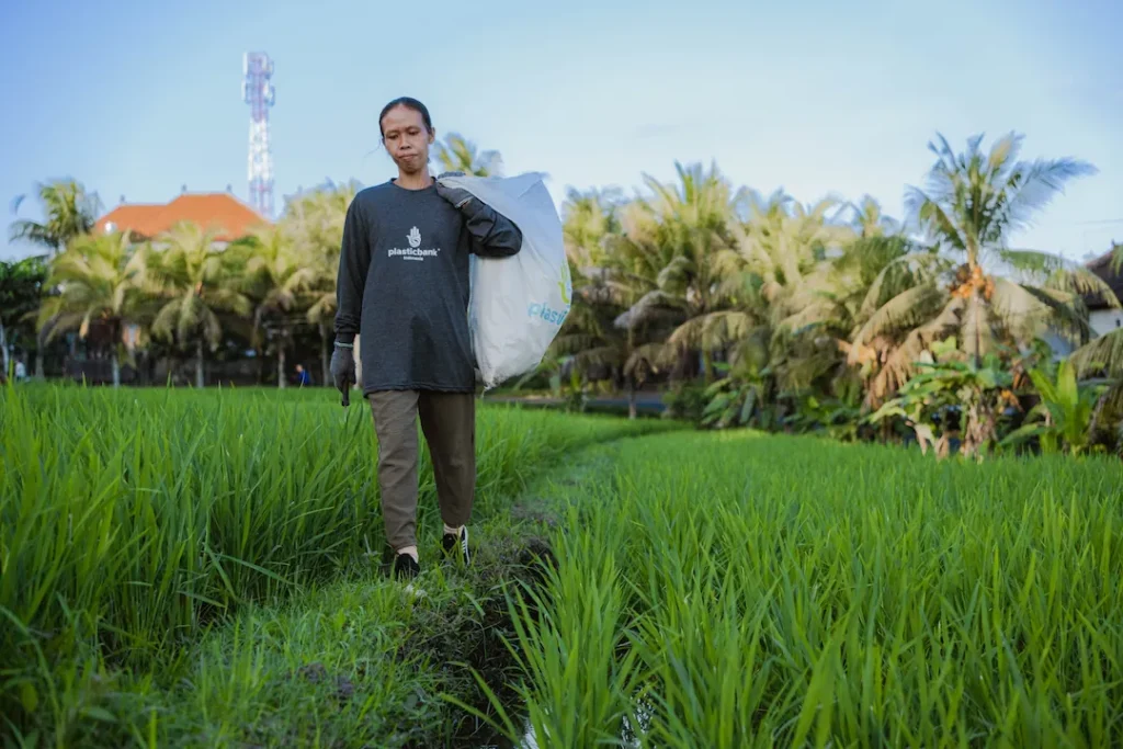 Woman walking in Bali collection plastic and trash
