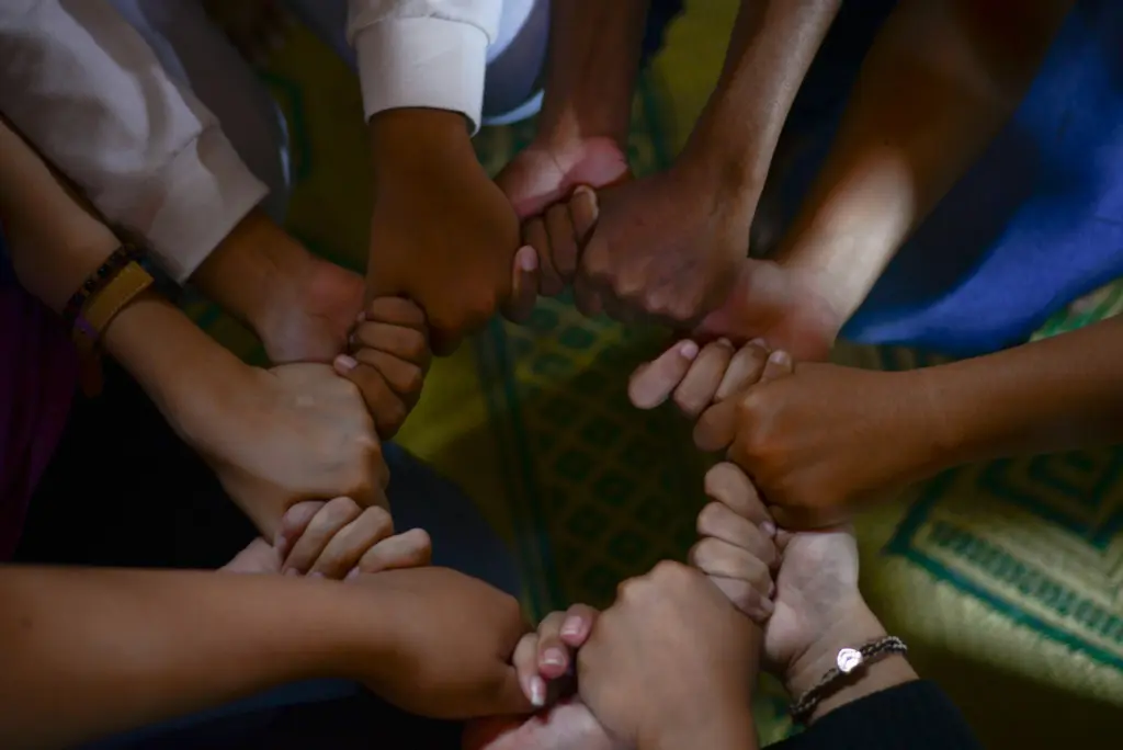 Hands joined in a circle, symbolizing global cooperation and shared responsibility under the High Seas Treaty to protect marine biodiversity.