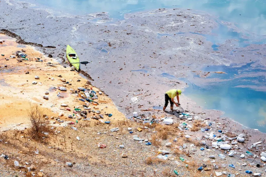 Informal waste pickers clean up waste as part of community-based plastic collection along a coastal community.