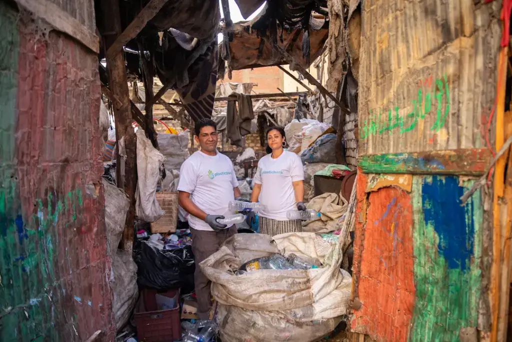 Two collectors holding recovered plastic bottles in a local collection branch in Egypt
