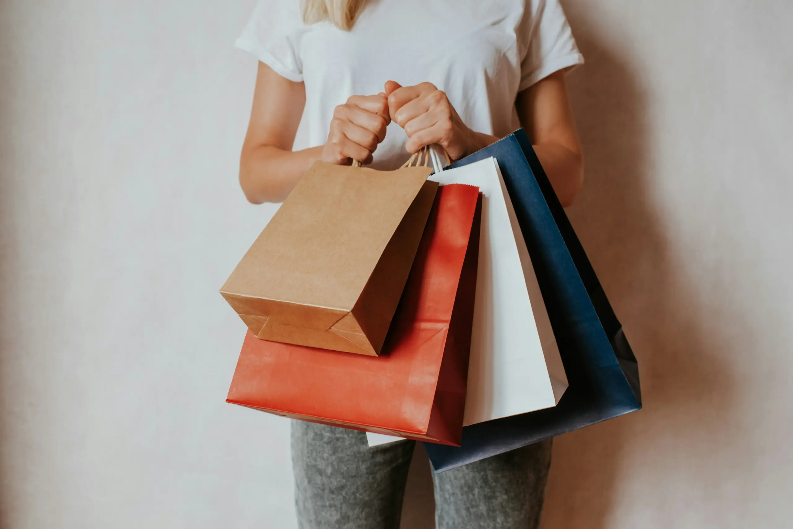 A woman carrying a several shopping bags at once