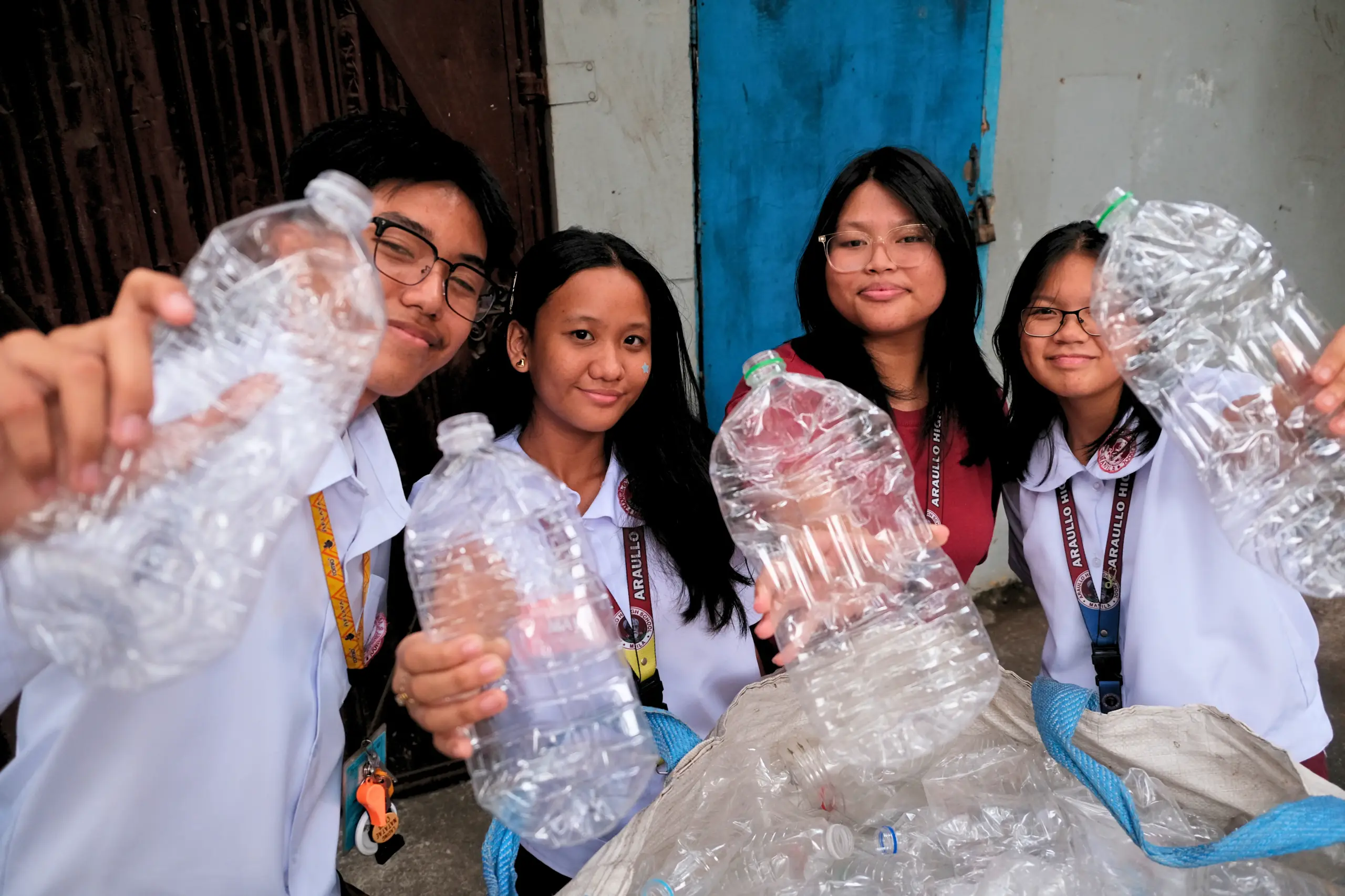 Group holding plastic water bottles