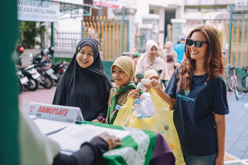 A parent and child bring their plastic collection to Plastic Bank