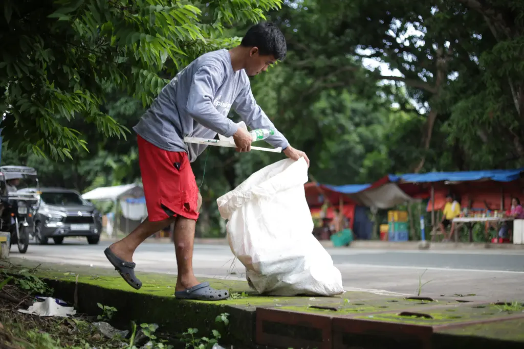 A waste worker collecting plastic to prevent it from going to landfills