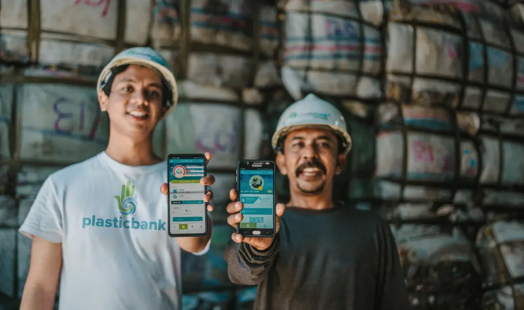 A Plastic Bank member and a collector showing the app they use to track collected plastic 