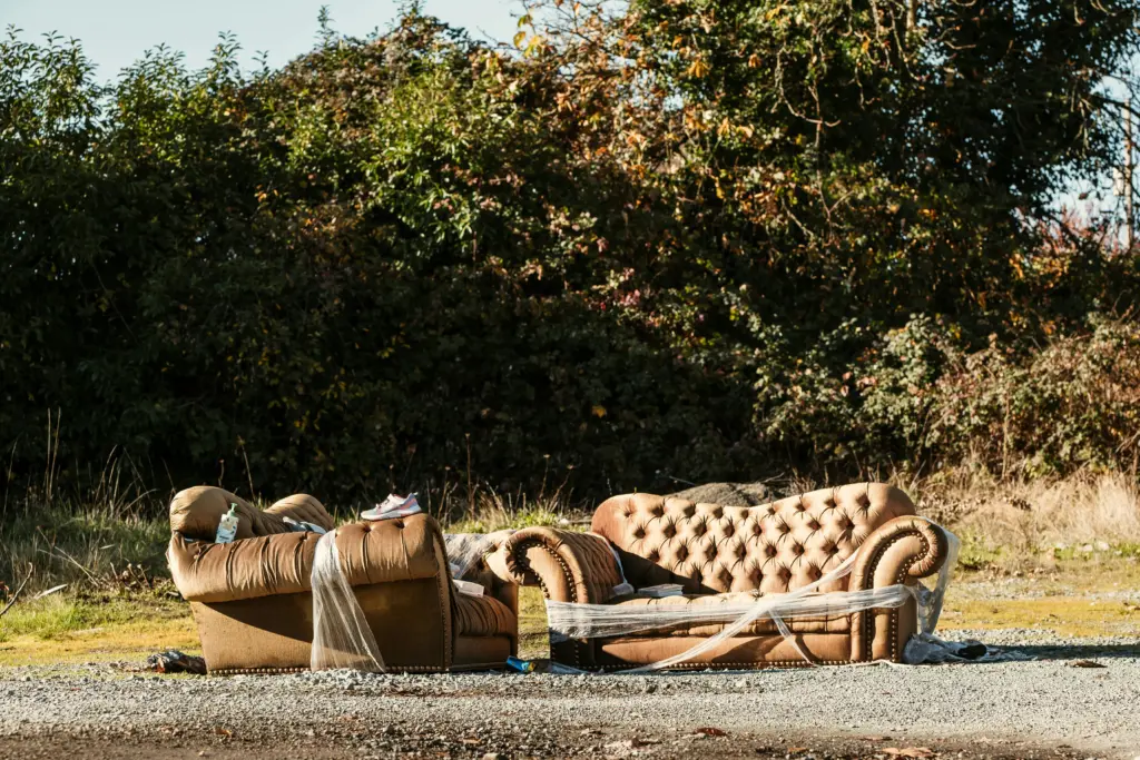 broken sofa outside for landfill disposal