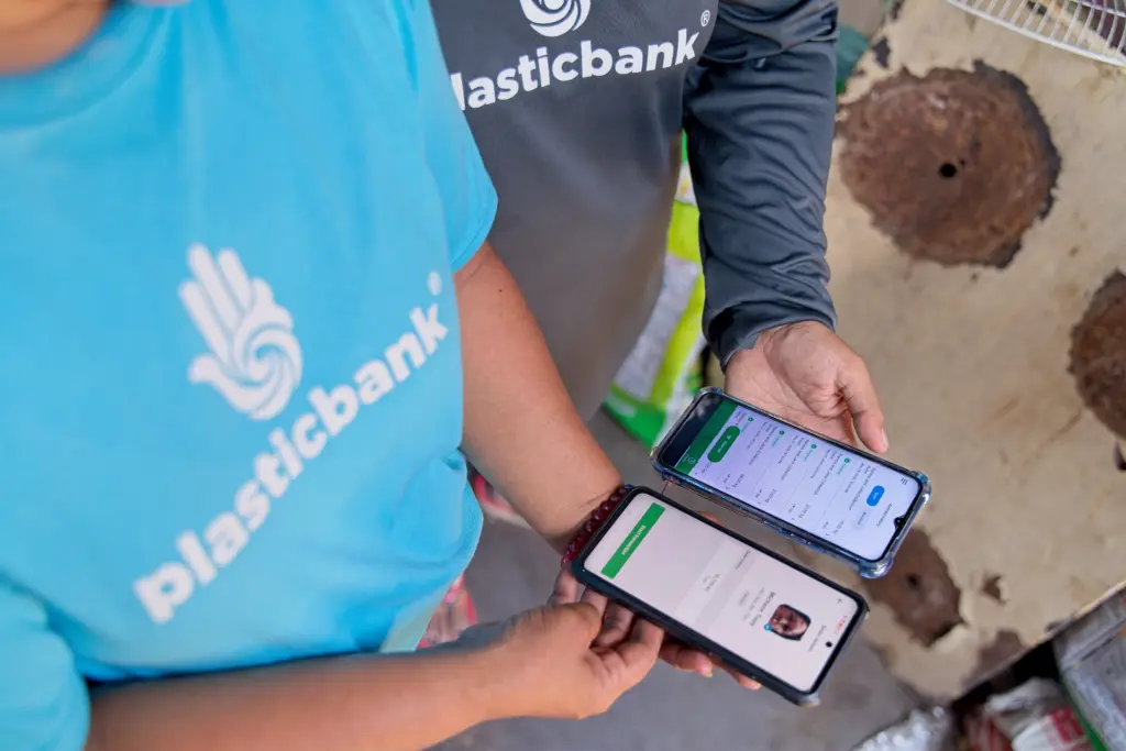Plastic Bank collector and branch owner making a transaction on the Plastic Bank app