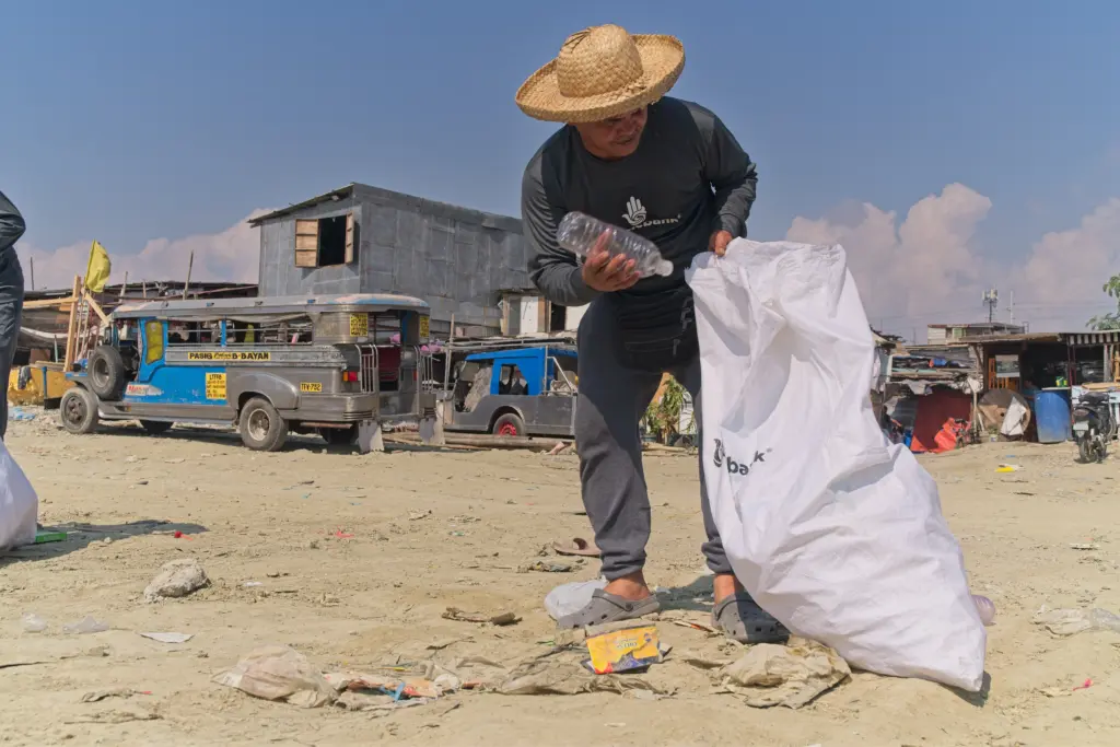 A Plastic Bank collector collecting plastic in the community