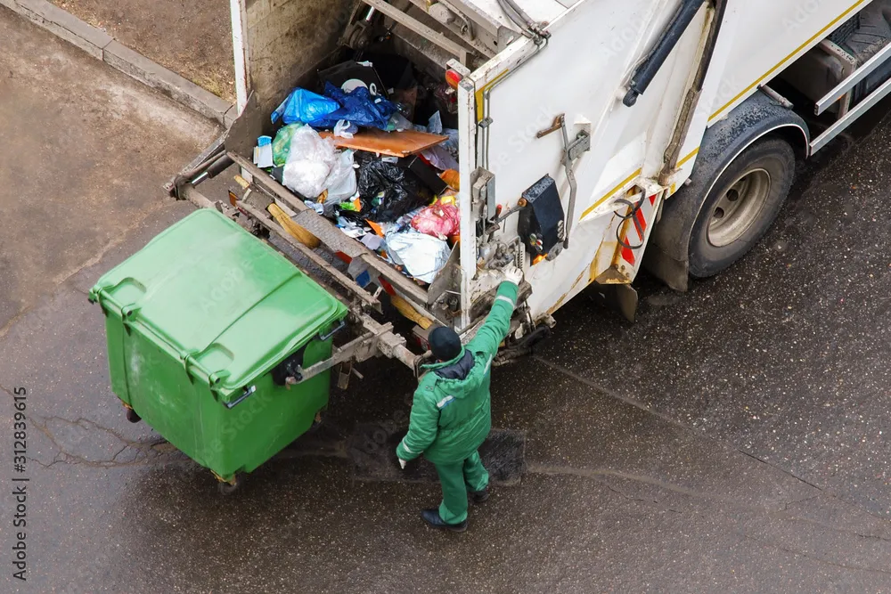 A garbage truck collecting trash from a bin